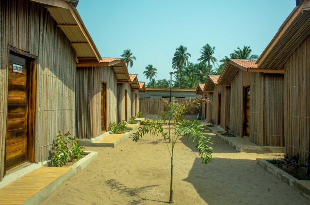A row of traditional lodges on the left-hand and on the right hand side at the Rosh Beach Resort