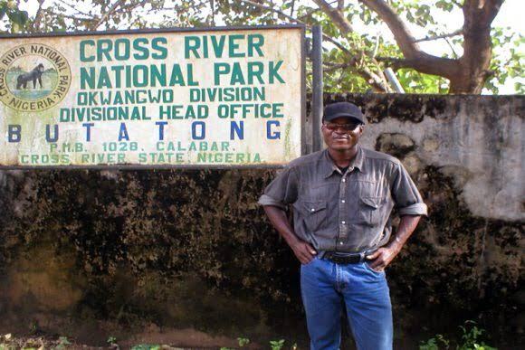 A man stand by the signpost of the Cross River National Park (Okwangwo Division)