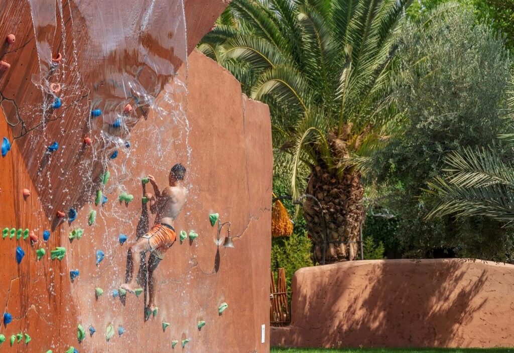 A teenager engaging in the wall-climbing sport at Oasiria Water Park in Marrakech