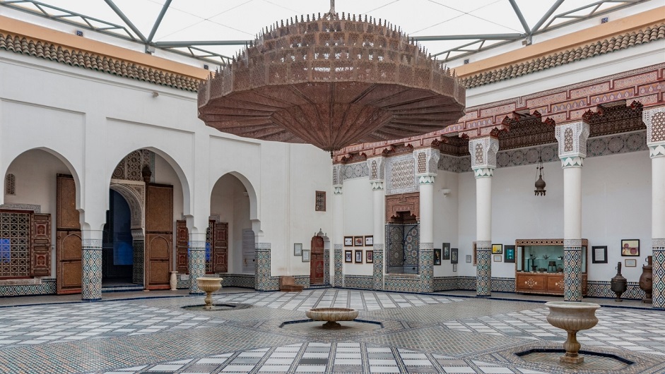 The massive courtyard of the Marrakech Museum with a giant chandelier and a collection of artworks